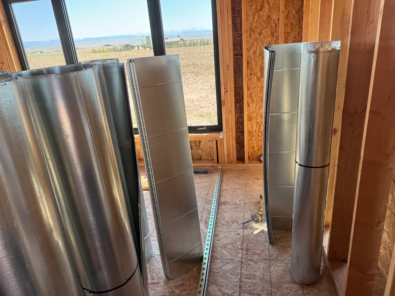 Galvanized duct and fittings staged inside a new construction home